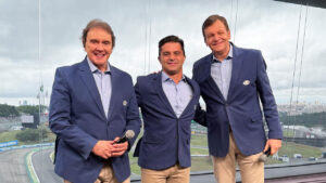 Reginaldo Leme, Max Wilson e Sergio Mauricio sorrindo e usando blazer azul nos bastidores do GP São Paulo de Fórmula 1 na Band