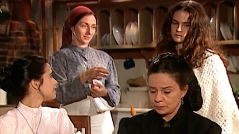Cena de novela Terra Nostra mostra quatro mulheres em uma cozinha antiga, com expressões sérias e roupas tradicionais do início do século XX