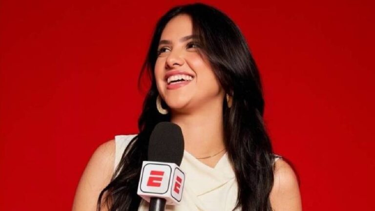 Mulher sorridente segura microfone da ESPN diante de fundo vermelho