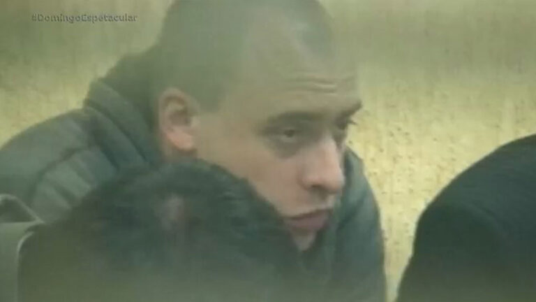 Alexandre Nardoni aparece de perfil com casaco cinza em imagem exibida pela reportagem do programa Domingo Espetacular na Record