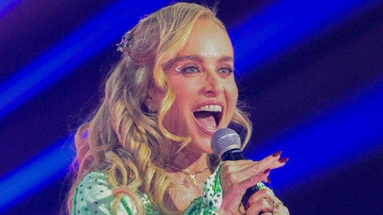 Angélica vestida como a personagem Fada Bela no palco do especial Globo 60 Anos, usando o figurino clássico da fada da novela Caça Talentos durante apresentação