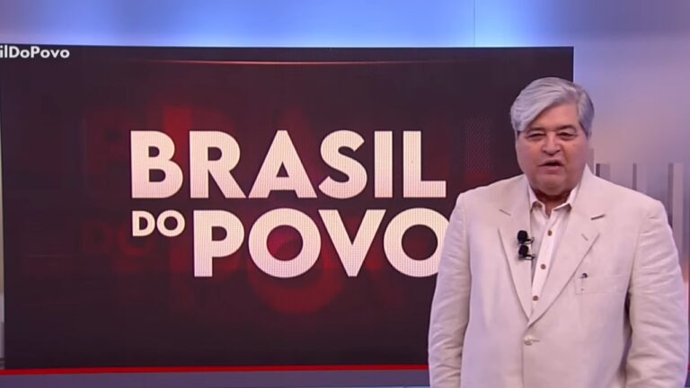 Apresentador de televisão aparece em estúdio, em pé, vestindo terno claro, ao lado de um grande telão com o título “Brasil do Povo” em letras brancas sobre fundo escuro, em cenário de programa jornalístico ou de debates.