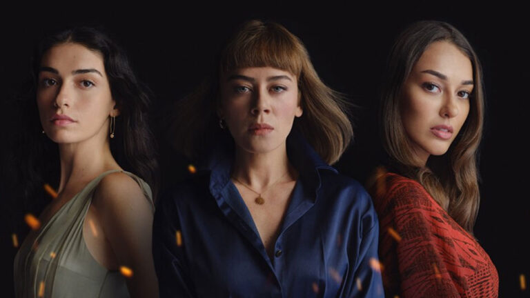 Cicek, Cemre e Ruya posam lado a lado com expressões sérias e faíscas de fogo ao redor na arte da novela Chamas do Destino