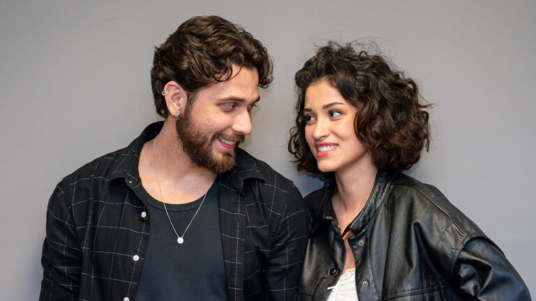 Gustavo Mioto como Diego e Maya Aniceto como Cindy sorrindo e se olhando em cena da novela Cinderela e o Pobre Milionário