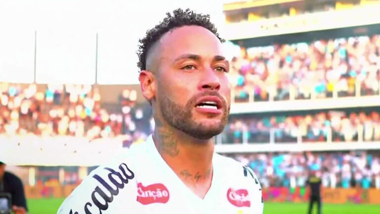 O jogador Neymar com a camisa do Santos no gramado de estádio durante partida com torcida na arquibancada