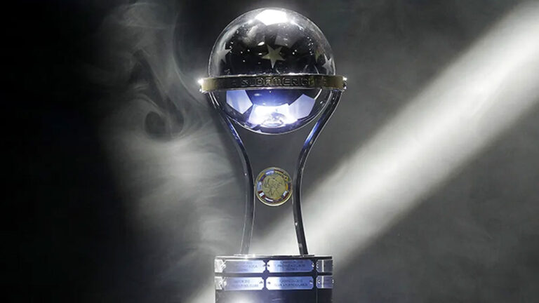 Taça da Copa Sul-Americana em destaque com fumaça e um feixe de luz ao fundo em imagem promocional do torneio de futebol