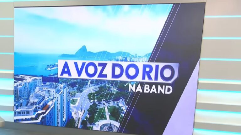 Tela de estúdio exibe o logotipo do programa “A Voz do Rio na Band” com imagem aérea do Rio de Janeiro ao fundo