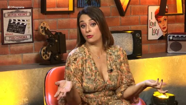 Mulher com vestido estampado fala gesticulando em estúdio com temática retrô e decoração de cinema