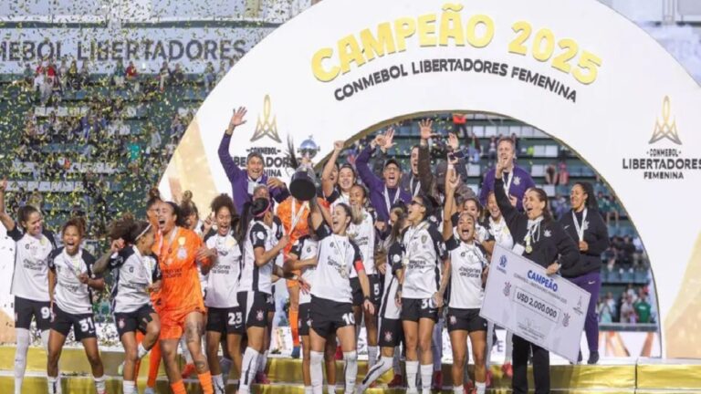 Jogadoras do Corinthians erguem taça da Libertadores Feminina 2025 em comemoração sob arco de campeão com confetes no estádio