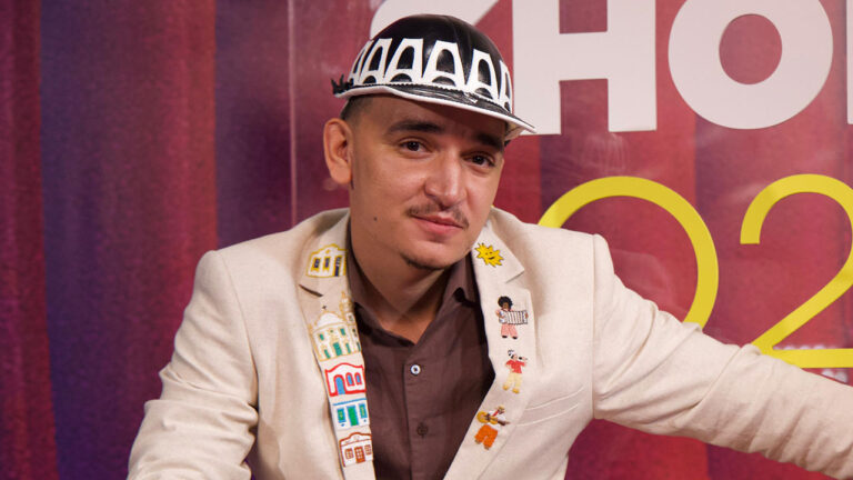 João Gomes usa chapéu de couro e paletó bordado com ícones nordestinos durante entrevista nos bastidores de premiação do Multishow