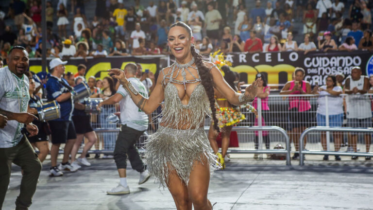 Josi Aoas sorri e samba com figurino prateado de franjas e trança longa durante ensaio técnico no Sambódromo do Anhembi em São Paulo