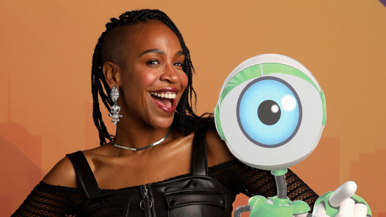 Karol Conká sorridente ao lado do robô RoBBB em foto promocional da sua participação no reality show Big Brother Brasil da Globo