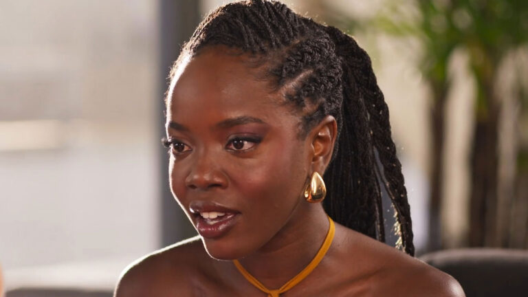 Clara Moneke interpreta Leo com tranças e brincos dourados grandes olhando para a lateral em cena de Dona de Mim