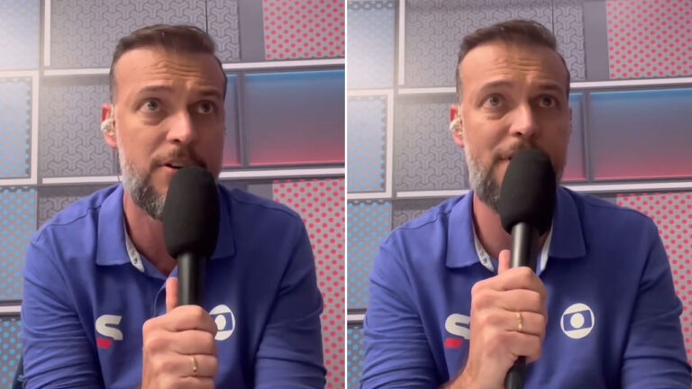 Márcio Meneghini segura microfone e fala em estúdio da Globo com camisa azul e painel geométrico colorido ao fundo