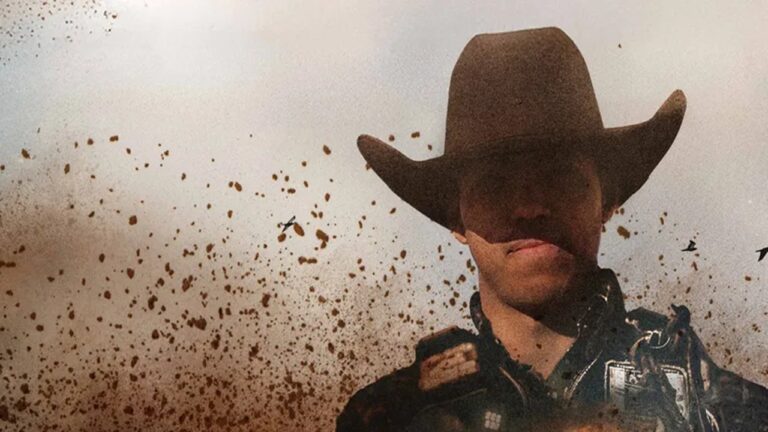 Homem com chapéu de caubói e roupa de montaria surge entre poeira em cena de documentário sobre rodeio