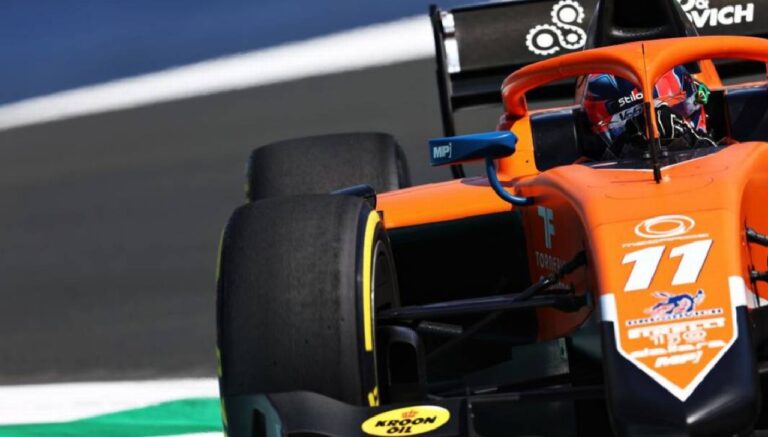 Carro de Fórmula 1 da McLaren número 11 em pista durante sessão de corrida com piloto ao volante e pneus em destaque