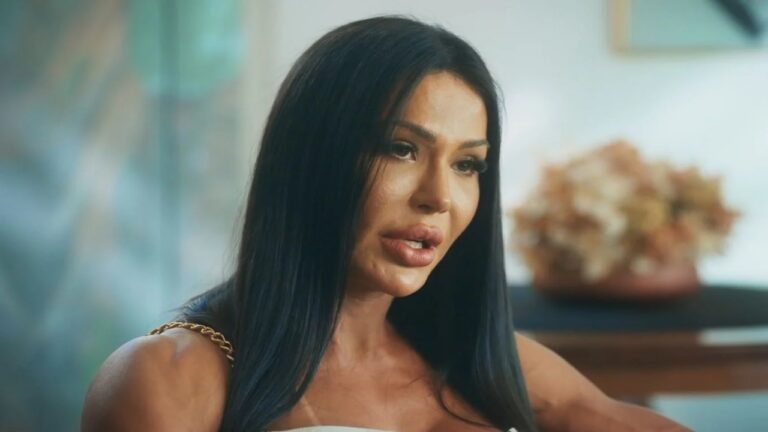 Mulher de cabelo longo e liso fala com expressão séria durante entrevista em ambiente interno iluminado