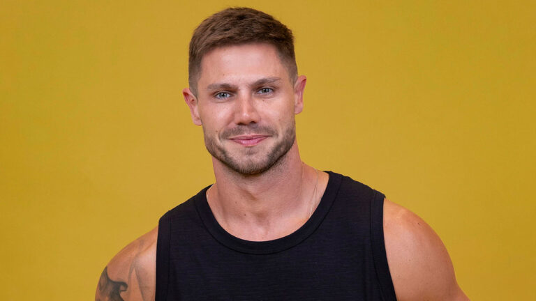 Jonas Sulzbach com camiseta preta posa diante de fundo amarelo em ensaio fotográfico