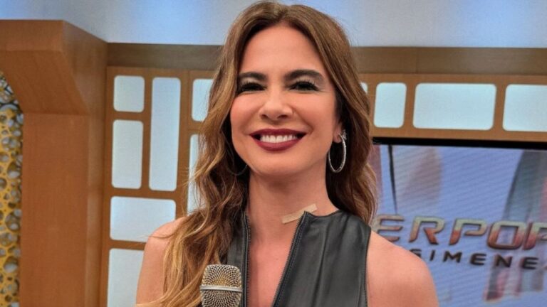 Apresentadora sorri segurando microfone em estúdio de TV durante gravação de programa de entretenimento