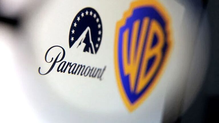 Logotipos da Paramount e da Warner Bros. aparecem lado a lado em parede branca. À esquerda, o nome “Paramount” com o símbolo da montanha cercada por estrelas; à direita, o escudo estilizado com as iniciais “WB”, representando dois grandes estúdios de cinema e televisão.
