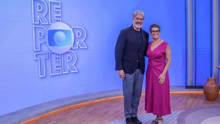 William Bonner e Sandra Annenberg posam no estúdio do Repórter com logotipo do programa exibido em telão azul ao fundo