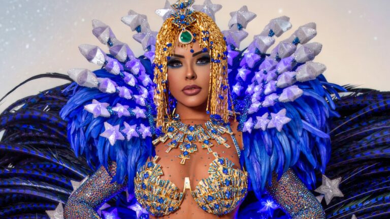 Ana Beatriz Godoi usa fantasia de Carnaval azul e dourada com pedrarias, ombreiras de estrelas iluminadas e adereço de cabeça egípcio com franjas