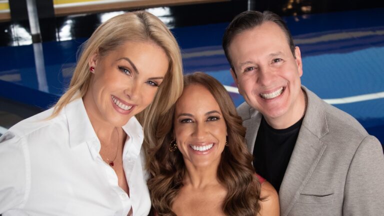 Ana Hickmann, Renata Alves e Celso Zucatelli sorriem juntos no estúdio do Hoje em Dia, Ana veste camisa branca, Renata tem cabelos ondulados e Celso usa paletó cinza-claro