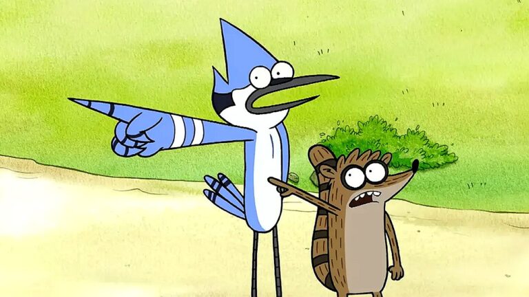 Dois personagens animados estão em um ambiente externo com grama ao fundo. Um pássaro azul alto aponta para frente com o braço estendido, enquanto um pequeno guaxinim ao seu lado também aponta na mesma direção. Ambos têm expressões de surpresa ou alerta, como se reagissem a algo fora da cena.