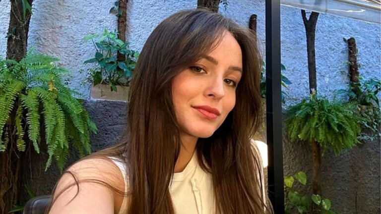 Larissa Manoela tira selfie ao ar livre com plantas ao fundo em ambiente residencial durante o dia