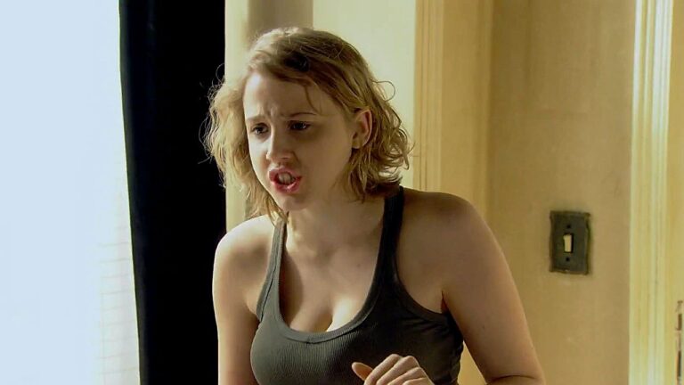 Mulher jovem discute em cena de filme nacional ambientada em quarto com expressão irritada