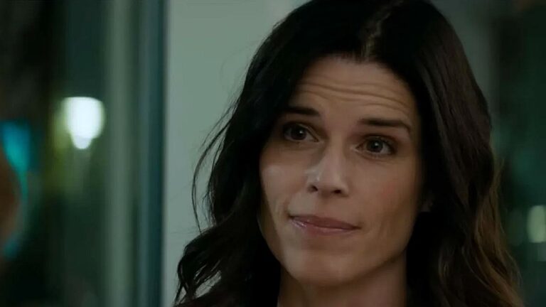 Mulher de cabelo escuro observa com expressão séria em cena de série dramática ambientada em interior moderno