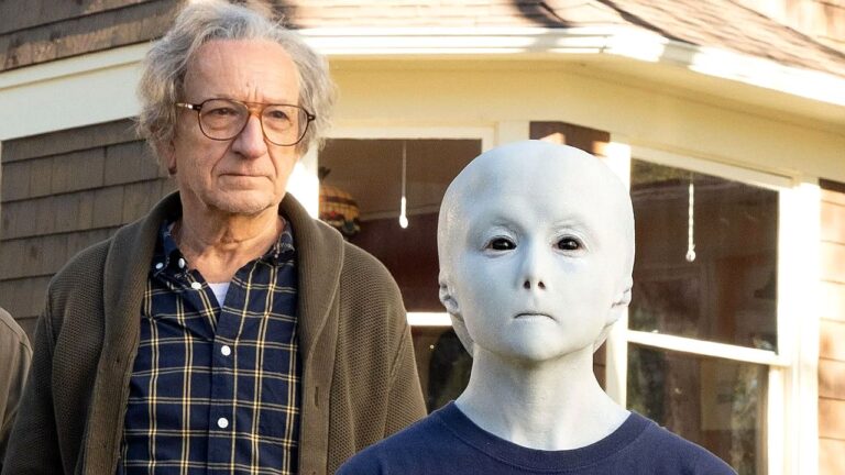 Homem idoso ao lado de figura humanoide branca com rosto sem expressão em cena de série de ficção científica