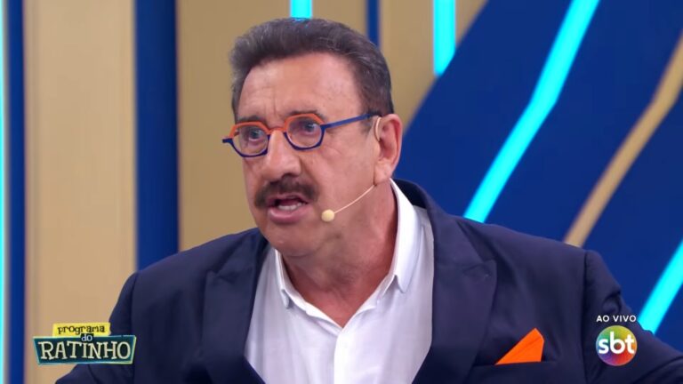 O apresentador Ratinho fala em seu programa de TV, usando terno escuro e microfone de lapela; no canto da tela aparecem o logotipo do Programa do Ratinho e o selo ao vivo do SBT.