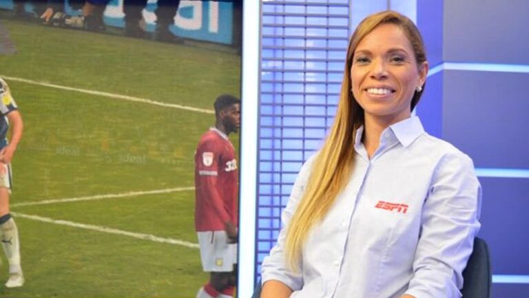 Mulher sorri em estúdio da ESPN com telão exibindo partida de futebol ao fundo