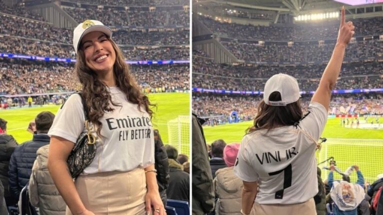 Rosana Ferreira sorri em arquibancada de estádio com camisa do Real Madrid e vira de costas mostrando nome Vini Jr nas costas