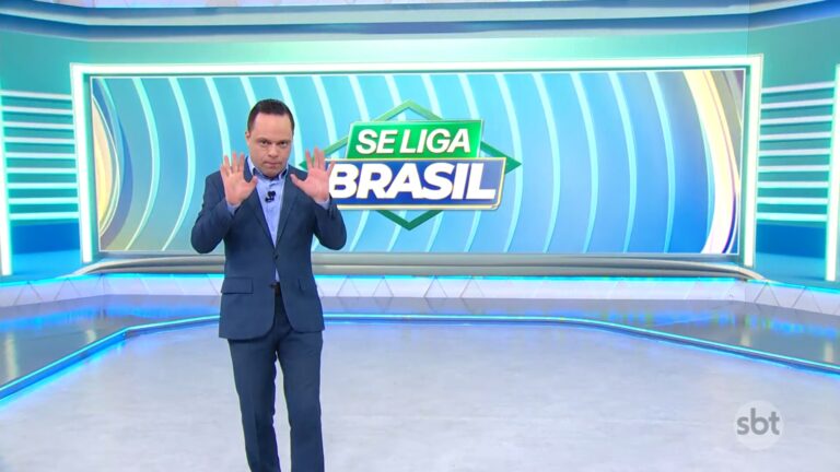 Thiago Gardinali gesticula no estúdio do Se Liga, Brasil, com telão exibindo logo do programa do SBT.
