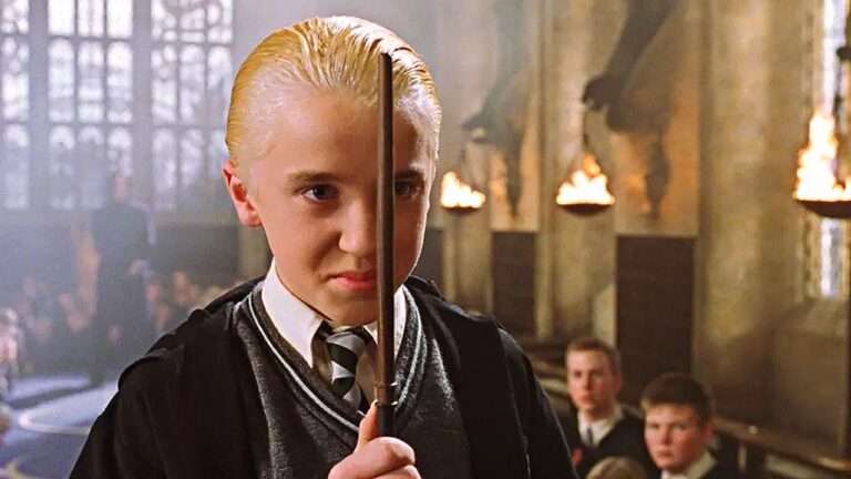 Draco Malfoy segura varinha em posição de duelo em cena do filme Harry Potter em Hogwarts