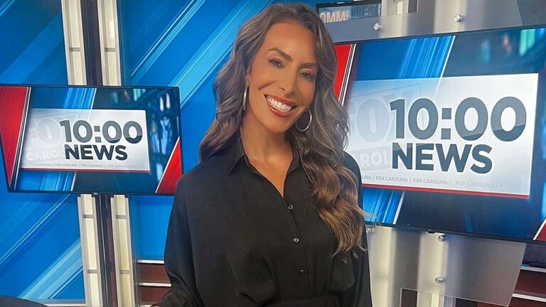 Apresentadora da Fox sorri em estúdio de telejornal com telas ao fundo exibindo 10 00 News durante transmissão ao vivo