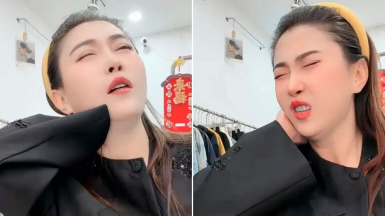 Wang Yefei faz caretas e leva a mão ao pescoço em vídeo gravado em ambiente interno com roupas ao fundo