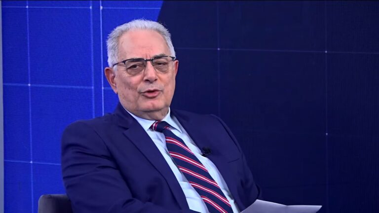 William Waack, homem grisalho de óculos, vestindo terno azul e gravata listrada, fala sentado no estúdio da CNN Brasil, com fundo azul no programa WW.