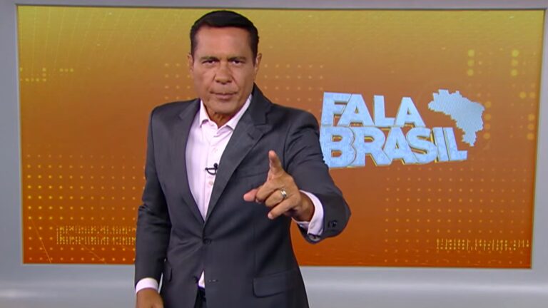 Willian Leite aponta para a câmera enquanto fala em estúdio, diante de um painel laranja com o título Fala Brasil e a silhueta do mapa do Brasil ao fundo.