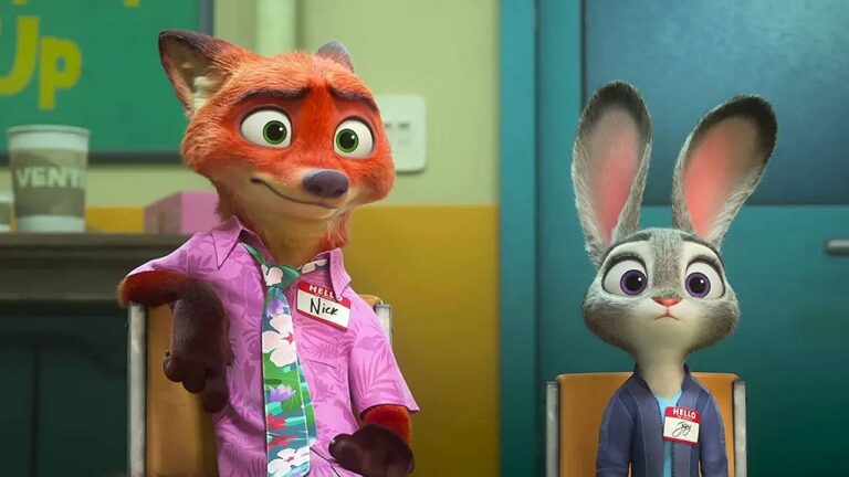 Dois personagens animados em Zootopia 2 estão sentados lado a lado em cadeiras, em um ambiente interno. À esquerda, há uma raposa de pelagem alaranjada vestindo camisa rosa e gravata colorida, com um crachá no peito. À direita, uma coelha cinza com orelhas longas usa roupa azul e também um crachá. Ambos têm expressões atentas e ligeiramente apreensivas. O cenário ao fundo lembra uma sala institucional ou de reunião, com cores suaves e elementos simples.