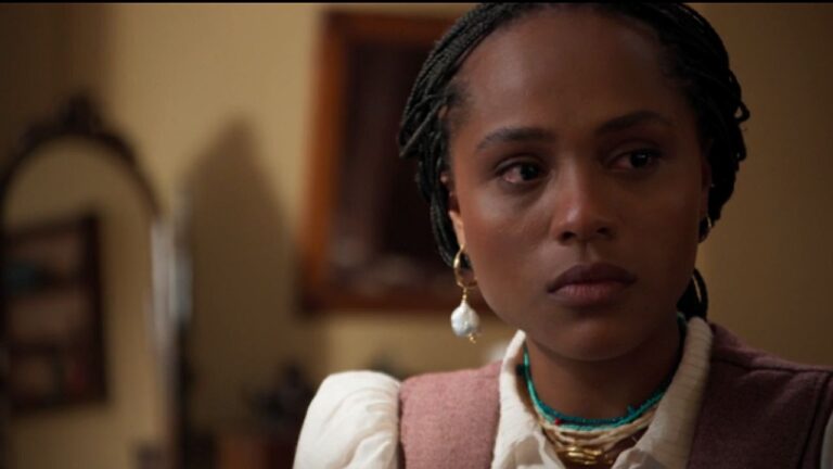 Mulher com tranças e brinco observa séria em cena dramática ambientada em casa