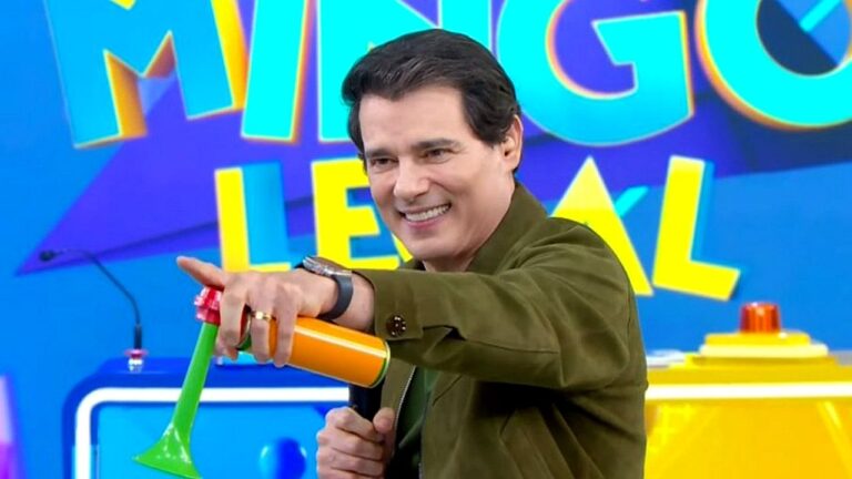Apresentador Celso Portiolli aponta no palco do Domingo Legal segurando buzina em quadro do programa