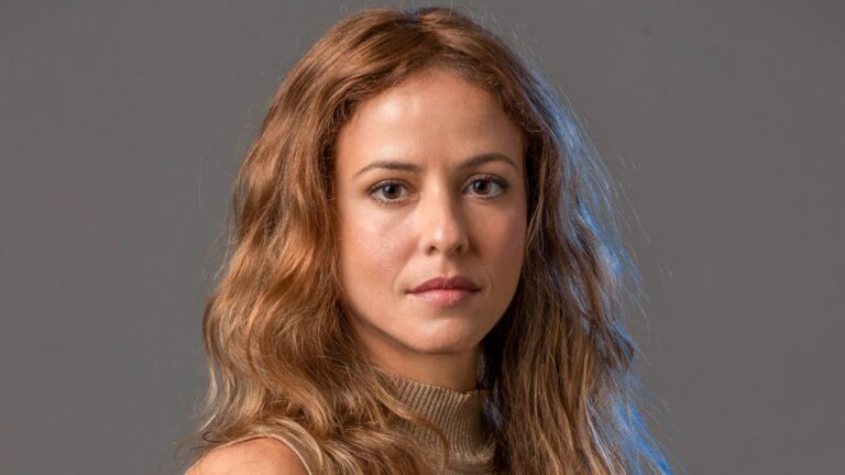 Fernanda de Freitas encara a câmera com expressão séria em retrato com fundo neutro e iluminação suave