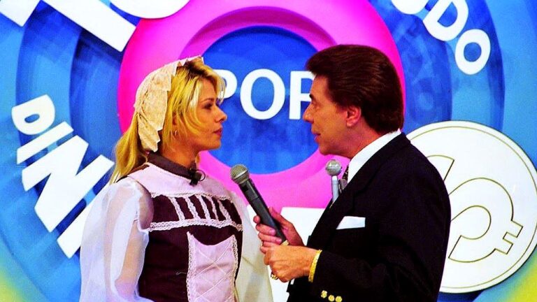 Silvio Santos entrevista mulher fantasiada com microfone no palco do Programa Silvio Santos