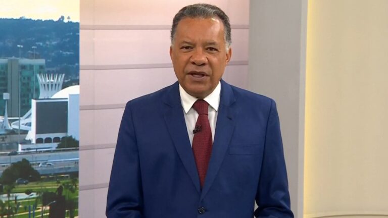 Heraldo Pereira usa terno azul e gravata vermelha durante apresentação do Bom Dia Brasil com Brasília ao fundo
