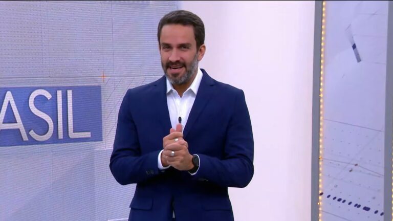 João Paulo Vergueiro, apresentador do Bora Brasil, sorri e fala no estúdio da Band, diante de telão com gráfico ao fundo.