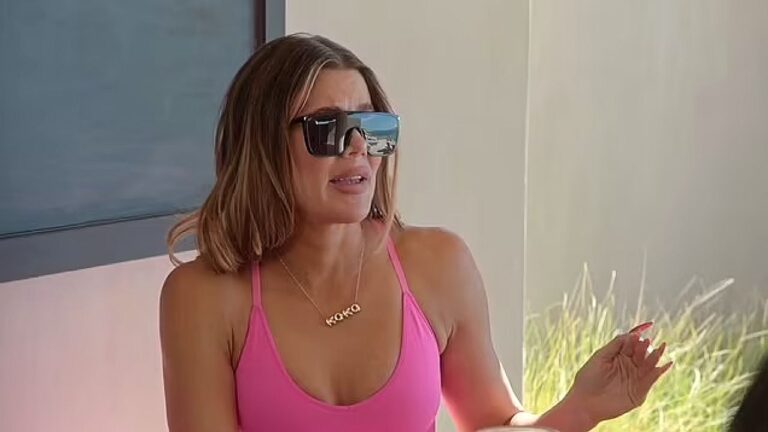 Mulher de óculos escuros e biquíni rosa conversa em área externa com vegetação ao fundo