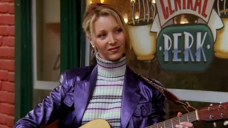 Phoebe Buffay toca violão no Central Perk em cena da série Friends